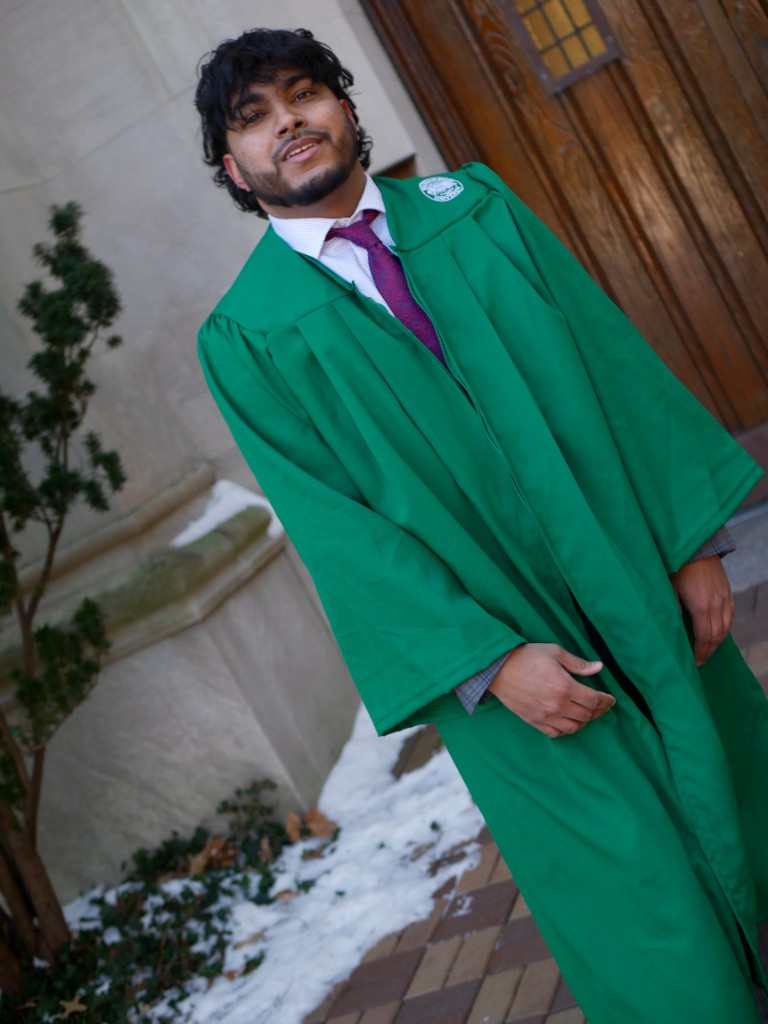 Graduate in green gown outside building
